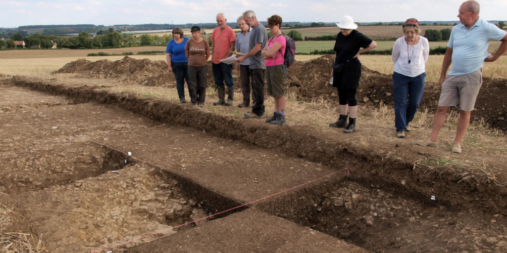 Derek explains the latest finds at Iron Age trackway to the assembled diggers