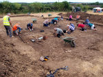 View of the excavation trench from the south-west cornr, with two groups of diggers working either side of it