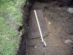 An iron plate is exposed at the base of the topsoil